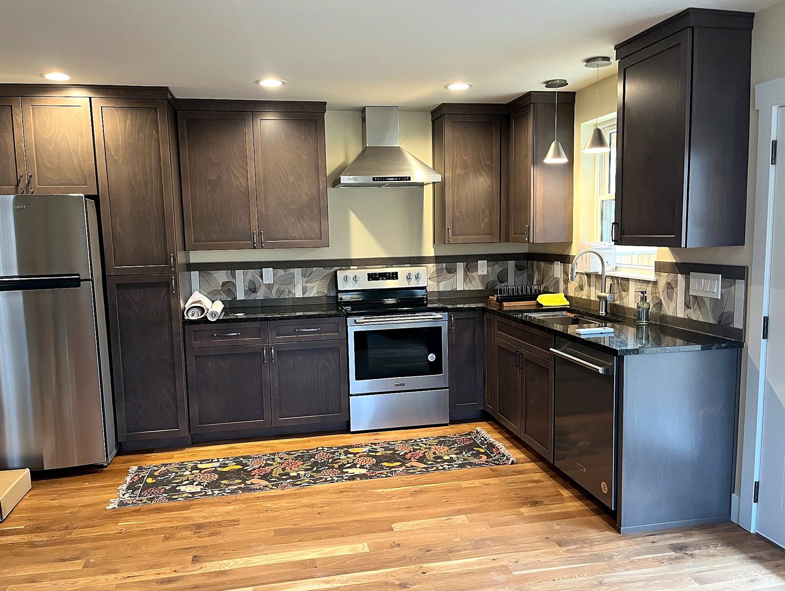 Finished Brookman ADU kitchen with dark cabinets and hardwood floor