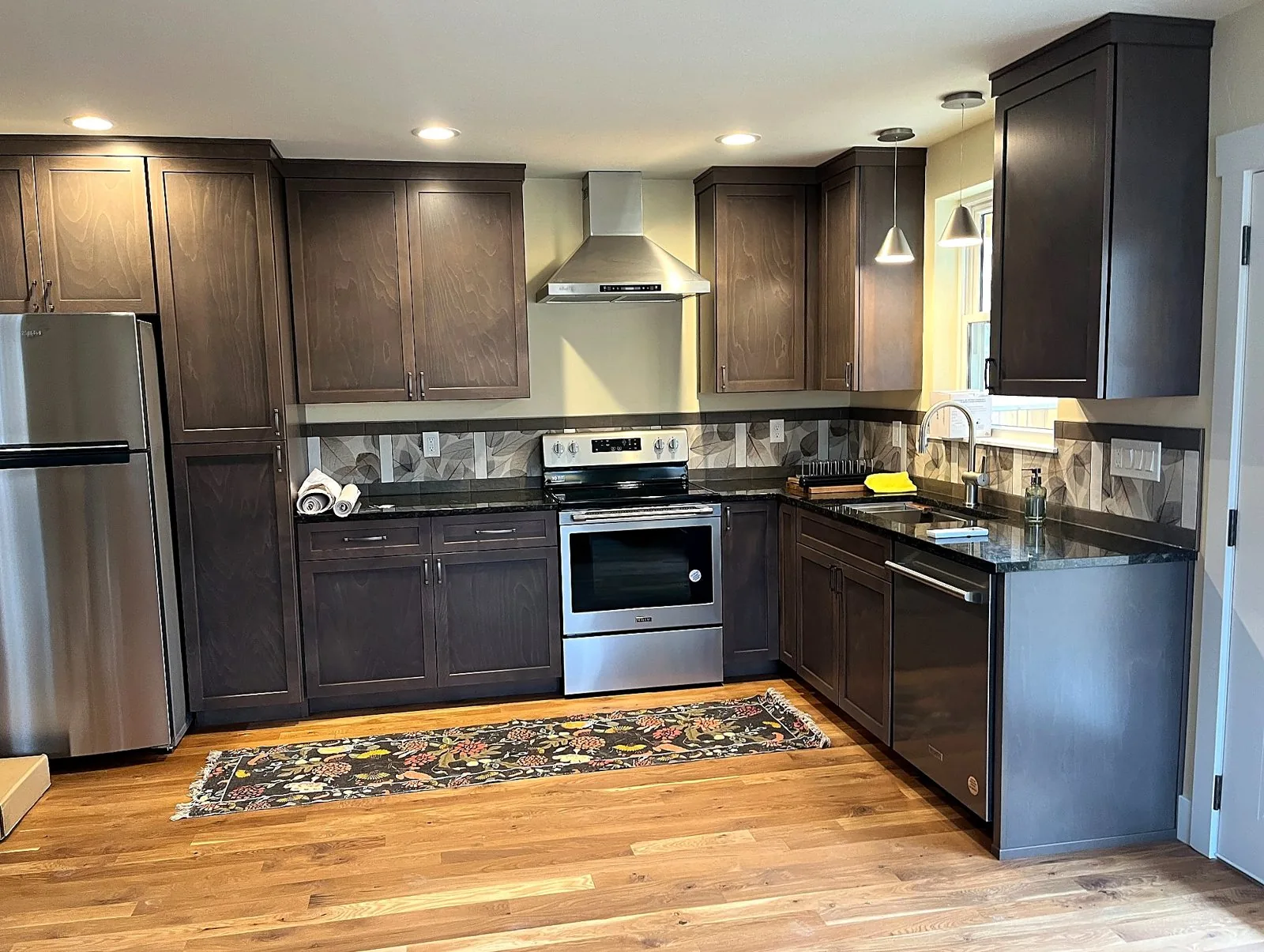 Finished Brookman ADU kitchen with dark cabinets and hardwood floor